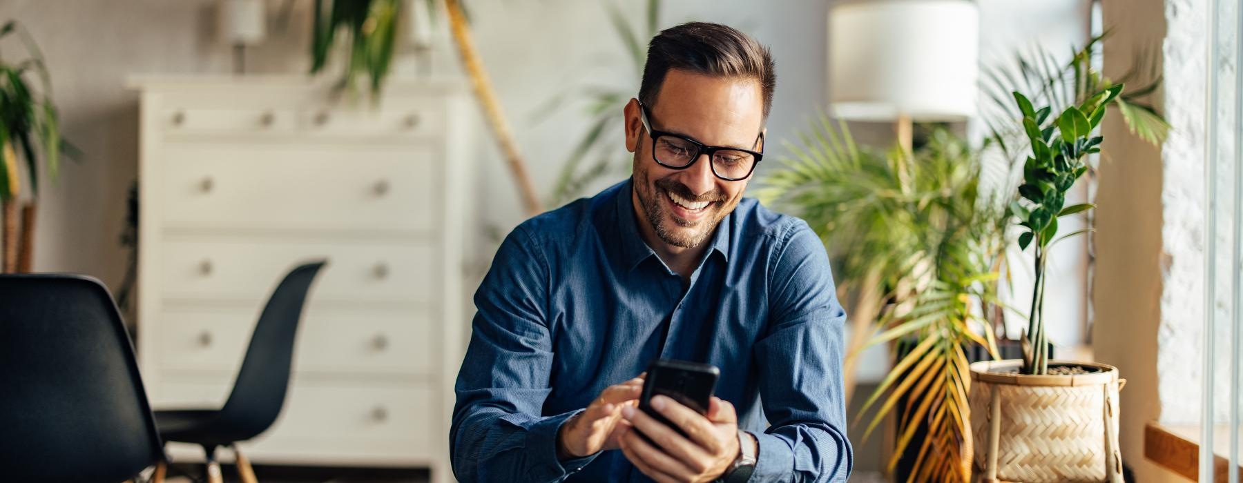 a man smiling looking at a phone