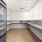 a room with white cabinets and a fridge